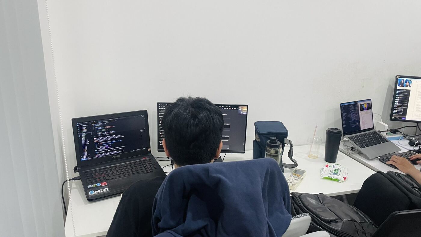 Góc làm việc của lập trình viên MONA với nhiều màn hình hiển thị code
